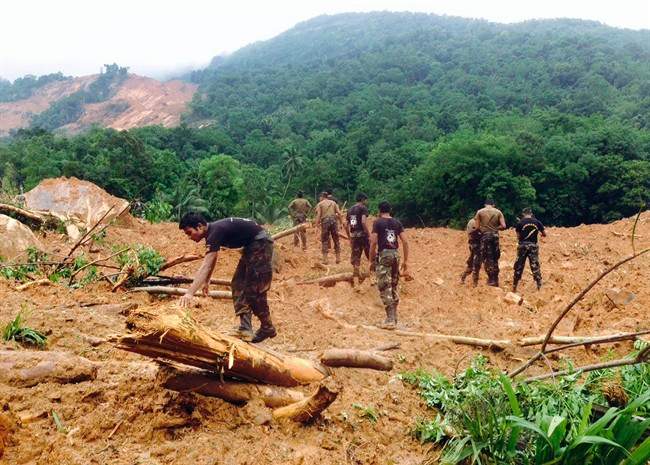 Sri Lankan army soldiers look for survivors at scene after a massive landslide in Kegalle district, about 72 kilometers (45 miles) north of Colombo, Sri Lanka, Thursday, May 19, 2016. Heavy rains Thursday pounded the central Sri Lankan region where at least three villages have already been swallowed by mountains of mud, forcing soldiers and police to suspend rescue work. (AP Photo/Eranga Jayawardena).