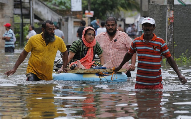 An elderly Sri Lankan woman is shifted on a makeshift raft at a flooded area in Colombo, Sri Lanka, Tuesday, May 17, 2016. The Disaster Management Center said that 114 homes have been destroyed and more than 137,000 people have been evacuated to safe locations as heavy rains continue. (AP Photo/Eranga Jayawardena).