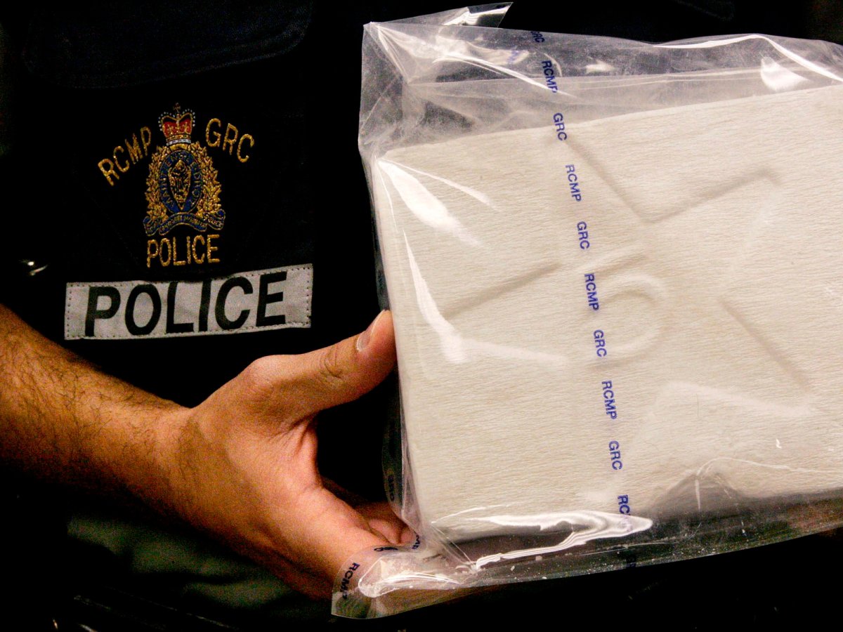 Police display a one kilogram brick of cocaine.