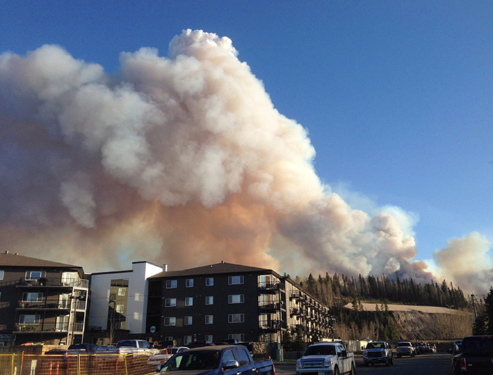 Smoke from a wildfire fills the sky in downtown Fort McMurray on Sunday, May 1, 2016.
