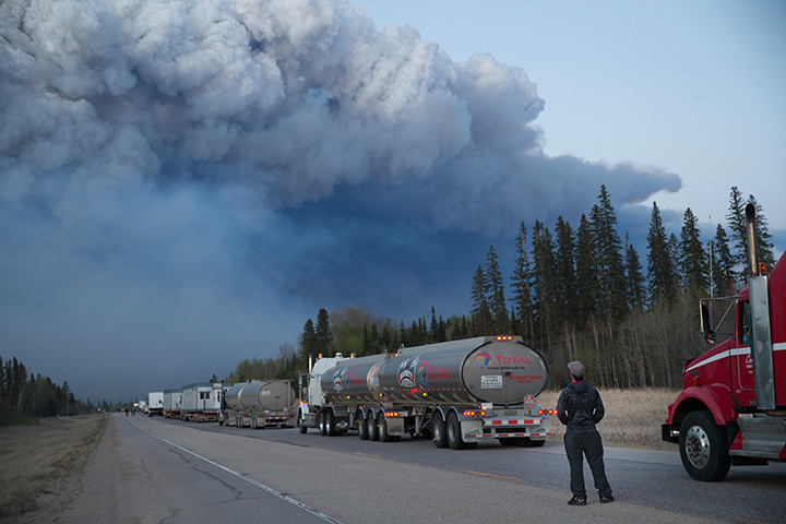 Drivers wait for clearance to take firefighting supplies into town on May 05, 2016 outside of Fort McMurray.