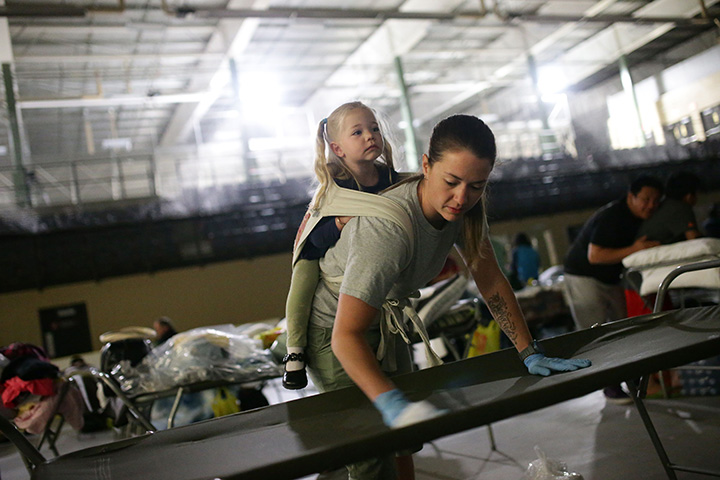 Marlee Hildebrandt and her daughter Oakley Hildebrandt, 2, clean cots at a makeshift evacuee centre in Lac La Biche, Alberta on May 5, 2016, after fleeing forest fires north of Fort McMurray.