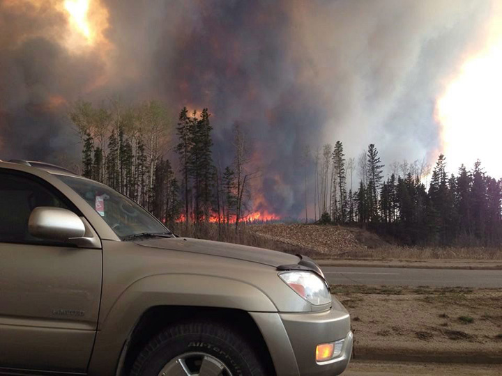 Smoke fills the air and trees burn in Fort McMurray, Alberta on Tuesday May 3, 2016.