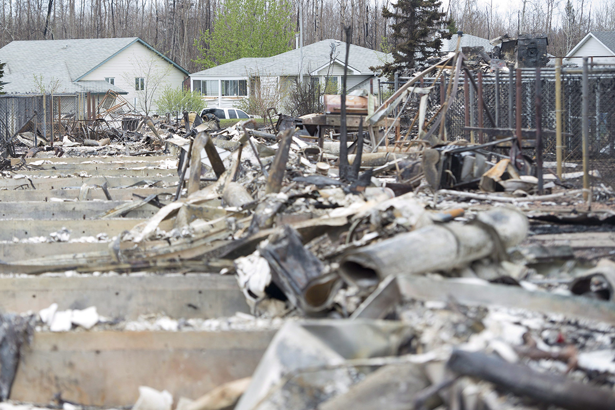 Burned out homes are seen in the foreground as other homes untouched by wildfires are seen in the background in Fort McMurray, Alta., on Monday, May 9, 2016. 