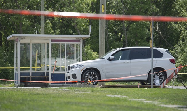 A white luxury SUV with a broken passenger-side window is shown at the scene in Laval, Que., Friday, May 27, 2016, where alleged mobster Rocco Sollecito was gunned down.
