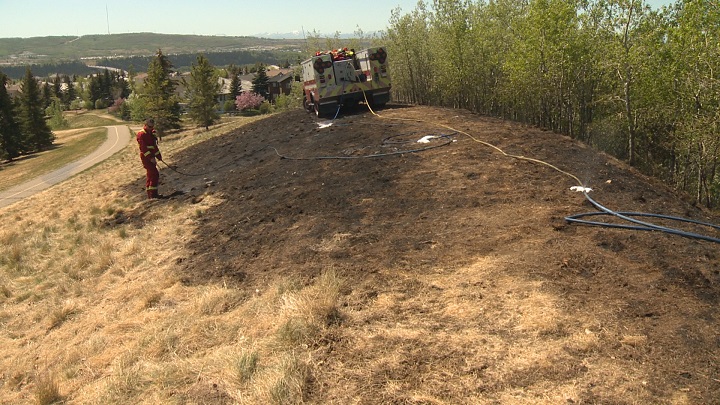 Firefighter battling one of two grass fires in Calgary Saturday.