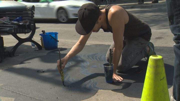 Artist Jason Botkin is hard at work on Saint-Laurent Boulevard. Sunday, May 22, 2016.