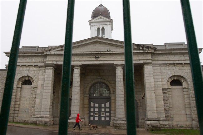 A pedestrian walks their dog in front of Kingston penitentiary in Kingston Ont., on Friday May 13, 2016. All three levels of government announced that the Kingston penitentiary will open up for tourists this summer. 