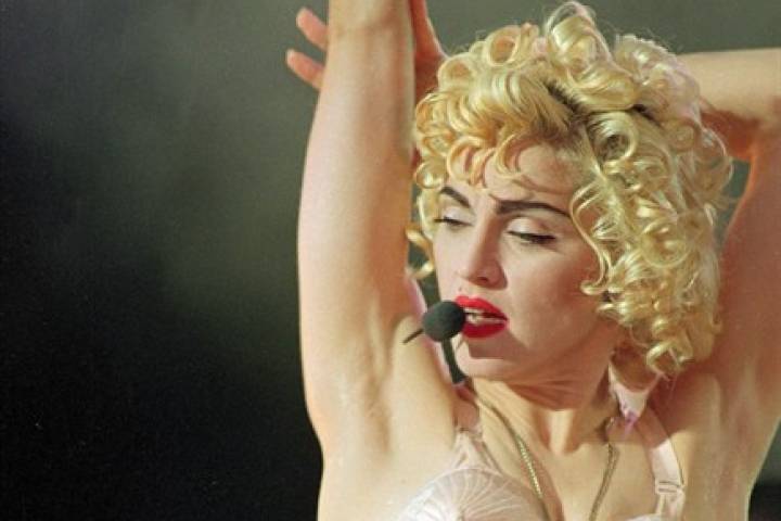 In this July 20, 1990 file photo, pop singer Madonna performs during her Blond Ambition tour in Wembley Stadium in London.
