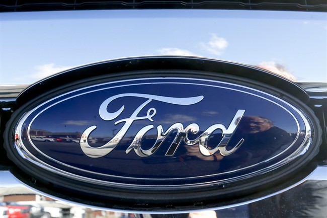This Thursday, Nov. 19, 2015, file photo shows the blue Ford oval badge in the grill of a pickup truck on in Butler, Pa. 