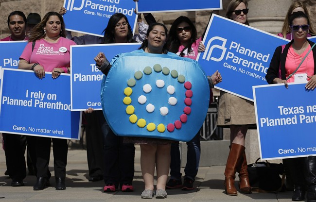 In this March 7, 2013 file photo, Alyssa Travino, center, of Edinburg, Texas, wears a birth control bill box costume during a Planned Parenthood rally on the steps of the Texas Capitol, in Austin, Texas. 