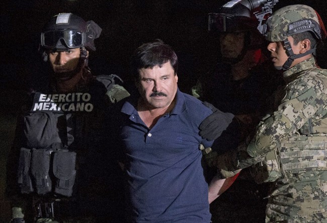 In this Jan. 8, 2016 file photo, Mexican drug lord Joaquin "El Chapo" Guzman is escorted by army soldiers to a waiting helicopter, at a federal hangar in Mexico City, after he was recaptured from breaking out of a maximum security prison in Mexico.
