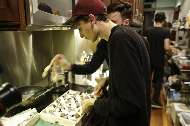 In this Monday, May 16, 2016 photo, Jonah Reider, a chef, prepares food during Brownstone, an experiential treasure-hunt of sound, taste, and color at the American Irish Historical Society, in New York. 