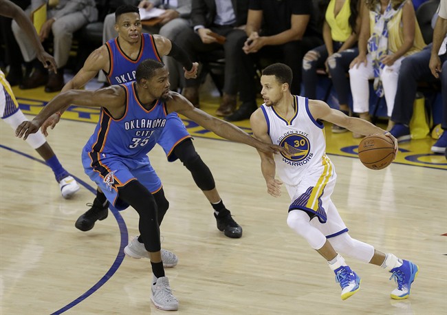 Golden State Warriors guard Stephen Curry (30) dribbles against Oklahoma City Thunder forward Kevin Durant (35) and guard Russell Westbrook during the first half of Game 7 of the NBA basketball Western Conference finals in Oakland, Calif., Monday, May 30, 2016. 