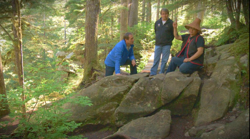 Nuxalk guide Chris Nelson, left , and Chief Wally Webber, centre, give Global BC's a  tour of the petroglyphs near Bella Coola, B.C.