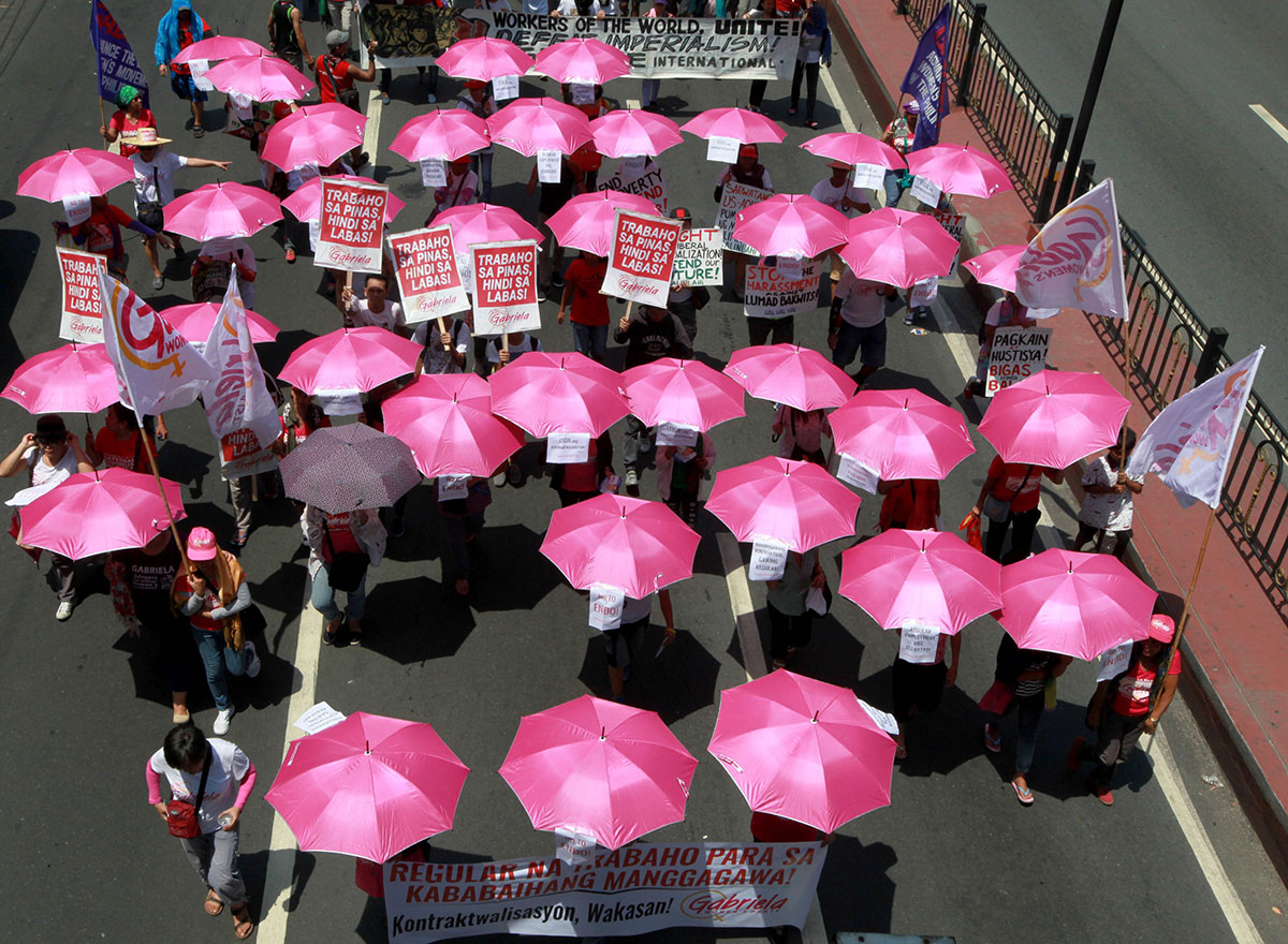 Hundreds of protesters, mostly workers, march with pink umbrellas towards the Presidential Palace to mark the International Labor Day Sunday, May 1, 2016 in Manila, Philippines.
