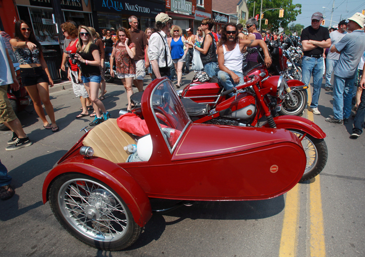 A biker poses with his motorcycle and sidecar in Port Dover, Ont., Friday, July 13, 2012.