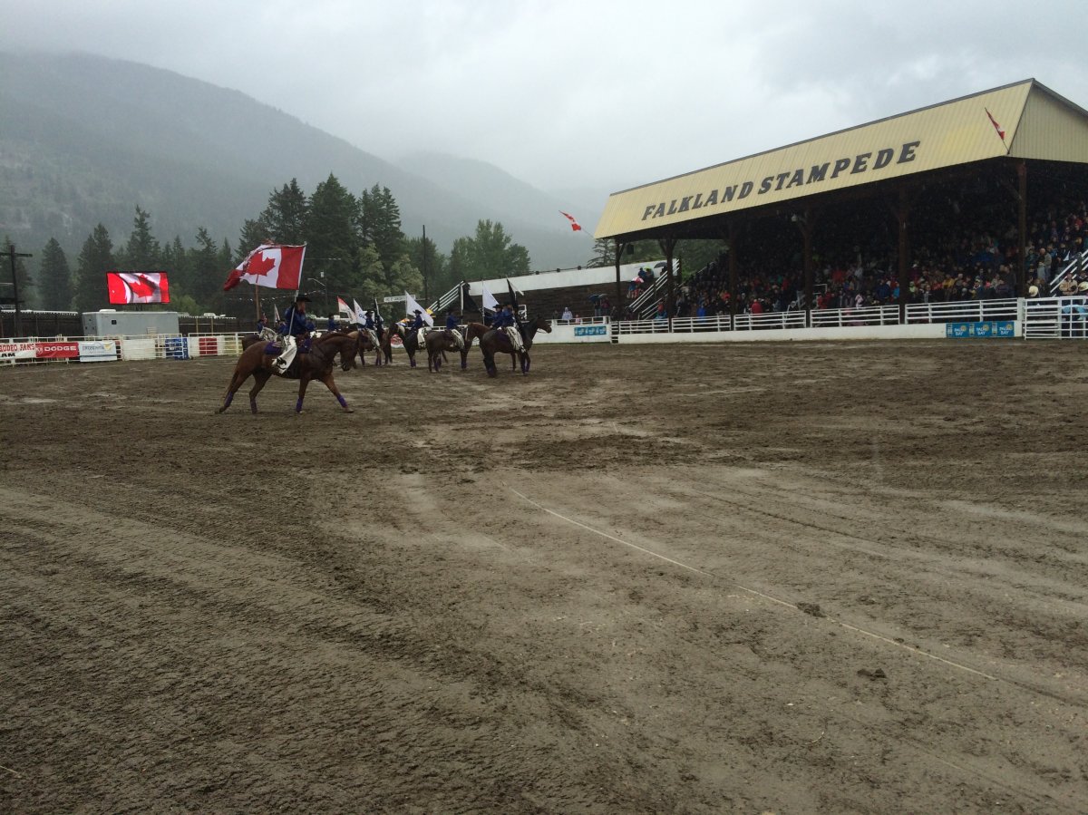 A rider circles the arena at the Falkland Stampede Grounds carrying the Canadian Flag as the national anthem is sung. 