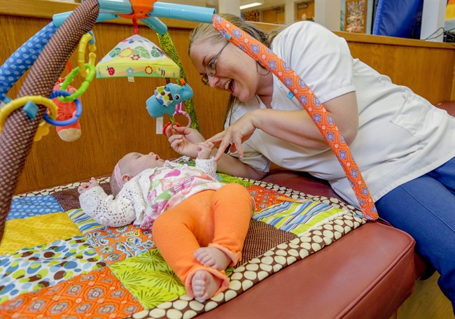 In this May 18, 2016 photo, Katie Young, an inmate at the Decatur Correctional Center, plays with her baby, Marissa, in the prison nursery where they live, in Decatur, Ill. 