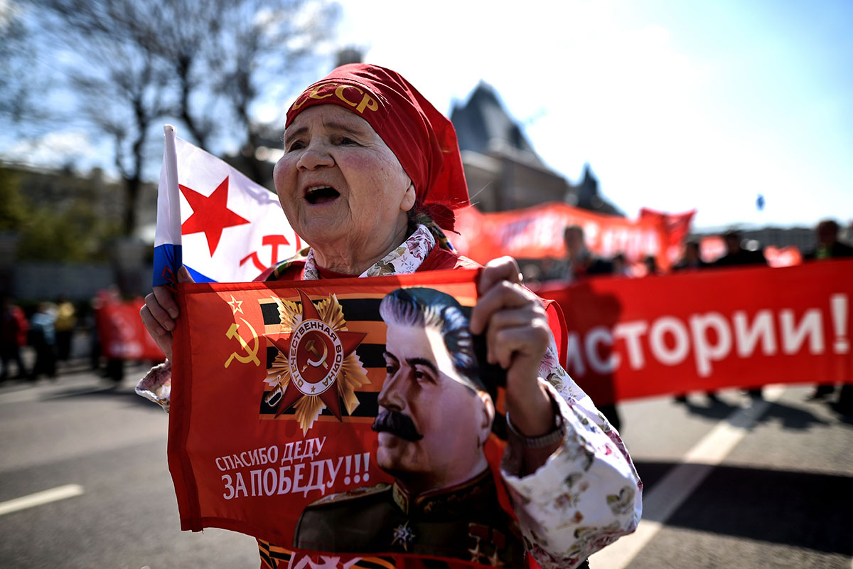 A Russian Communist party activist carries a banner with an image of late Soviet leader Joseph Stalin during a May Day rally in central Moscow on May 1, 2016.