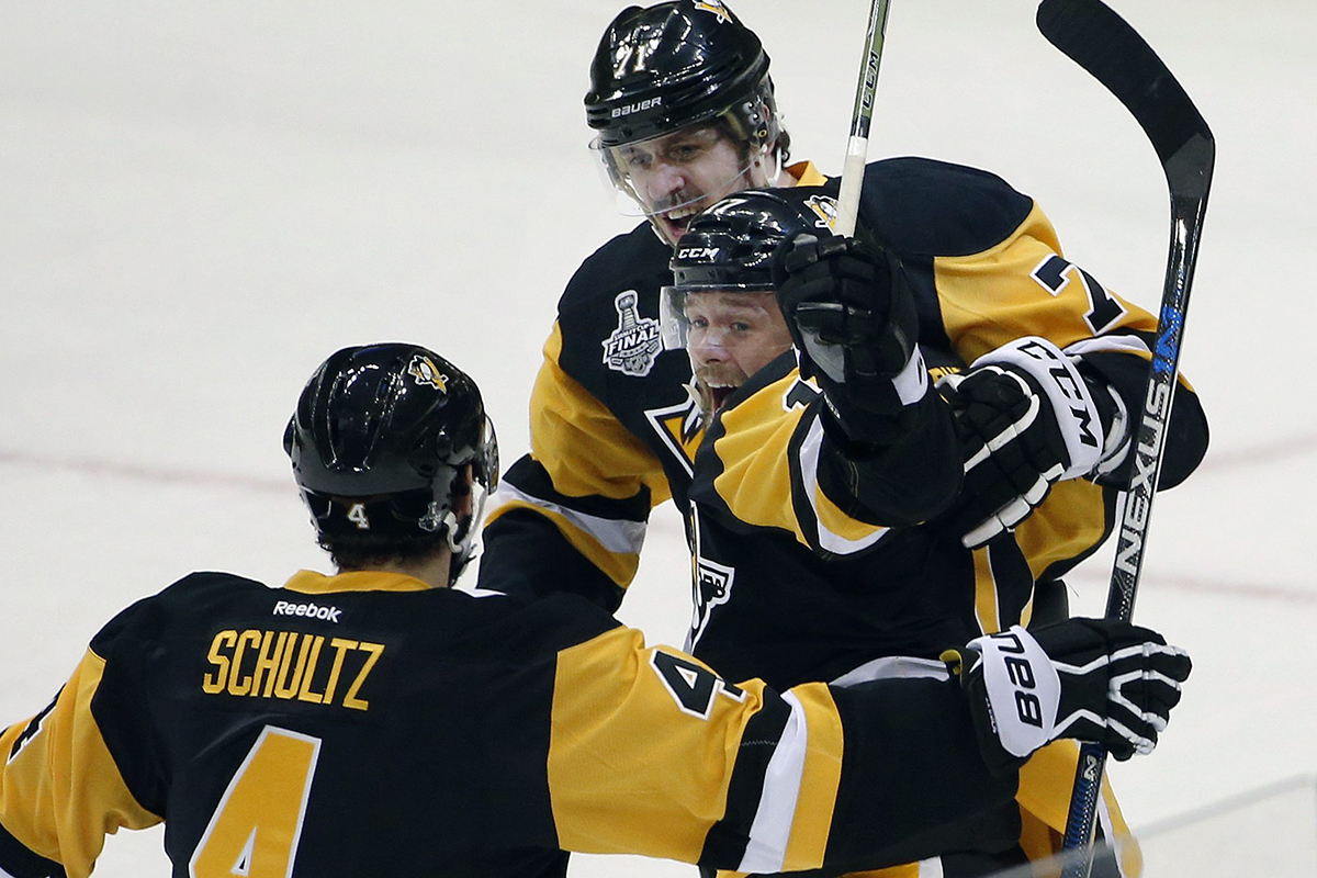 Pittsburgh Penguins' Bryan Rust, center, celebrates his goal against the San Jose Sharks with Justin Schultz (4) and Evgeni Malkin, rear, during the first period in Game 1 of the Stanley Cup final series Monday, May 30, 2016, in Pittsburgh. (AP Photo/Gene J. Puskar).