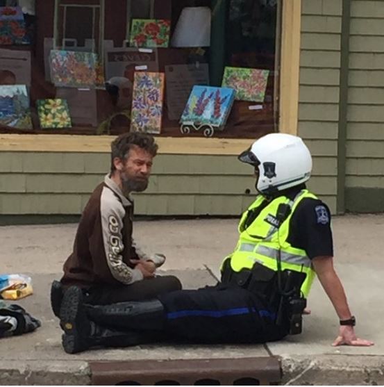 A photo of a Halifax Regional Police officer chatting with a panhandler along Spring Garden Road has gone viral.
