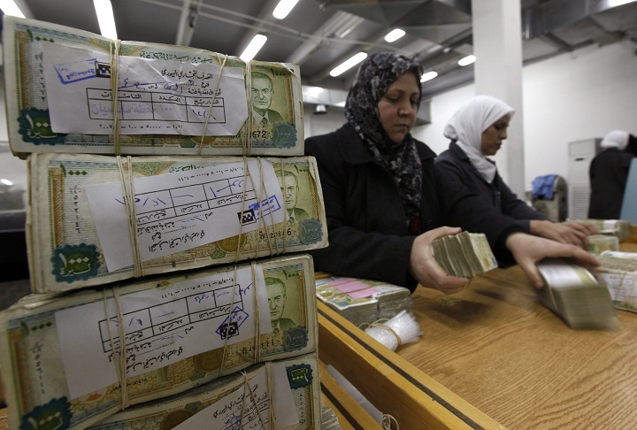 Syrian employees stack packets of Syrian currency in the Central Syrian Bank in, Damascus, Syria, on Wednesday Jan. 13, 2010. The value of the country's currency has plummeted. 