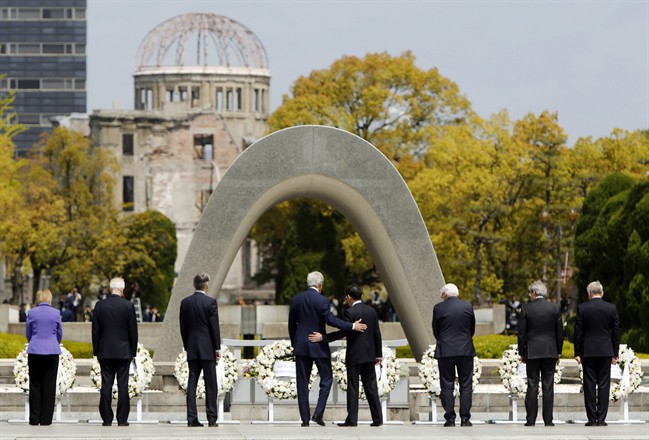 FILE - In this April 11, 2016, file photo, U.S. Secretary of State John Kerry, fourth from left, puts his arm around Japanese Foreign Minister Fumio Kishida after they and fellow G7 foreign ministers laid wreaths at the cenotaph at Hiroshima Peace Memorial Park in Hiroshima, western Japan. U.S. President Barack Obama will travel to Hiroshima in May 2016 in the first visit by a sitting American president to the site where the U.S. dropped an atomic bomb. Obama's visit will bolster his call for denuclearization and honor victims of the bombing that killed 140,000 Japanese on Aug. 6, 1945. The president's visit had long been anticipated. (Jonathan Ernst/Pool Photo via AP, File).