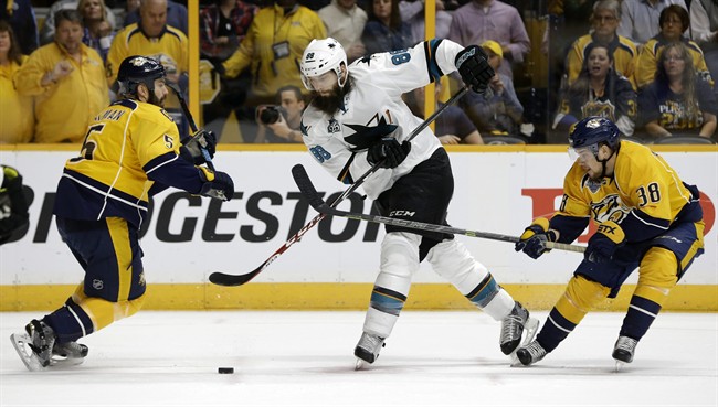 San Jose Sharks defenseman Brent Burns (88) passes the puck between Nashville Predators defenseman Barret Jackman (5) and forward Viktor Arvidsson (38), of Sweden, during the first period in Game 6 of an NHL hockey Stanley Cup Western Conference semifinal playoff series Monday, May 9, 2016, in Nashville, Tenn.
