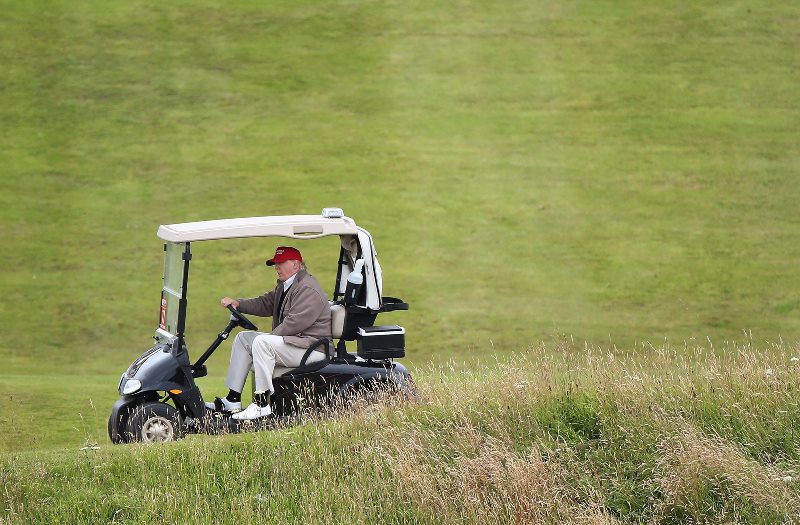 In this July 31, 2015 file photo, Republican presidential candidate Donald Trump drives his golf cart during the second day of the Women's British Open golf championship on the Turnberry golf course in Turnberry, Scotland.  