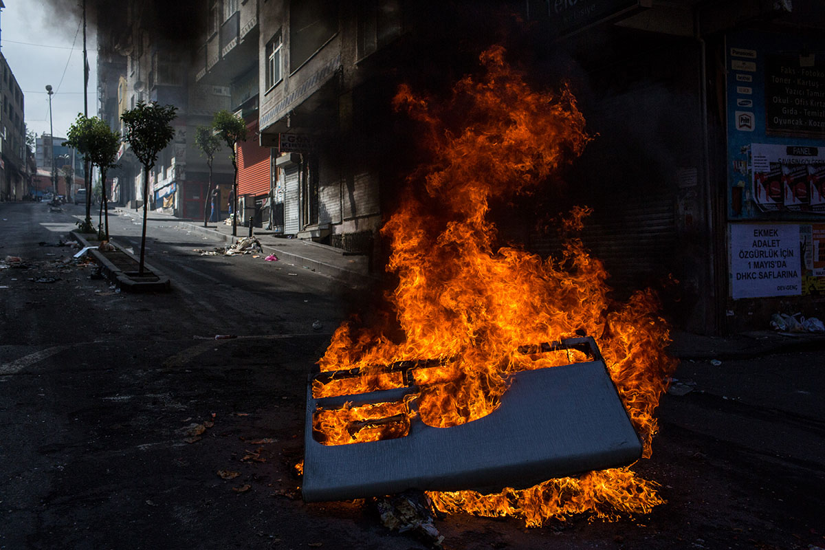 Debris burns on a street after police dispersed protesters in the Okmeydani neighbourhood during a May Day demonstration on May 1, 2016 in Istanbul, Turkey