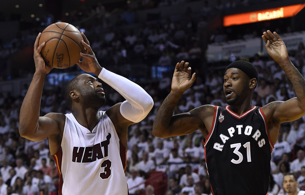 Miami Heat guard Dwyane Wade (L) is defended by Toronto Raptors guard Terrance Ross.