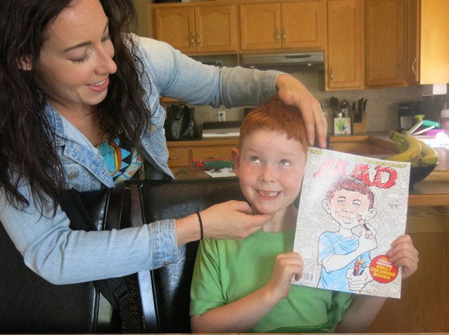 7-year-old TJ Desjarlais, right, and his mom Carly pose in Medicine Hat, Alta., on May 6, 2016. Desjarlais is basking in the limelight after being featured in Mad Magazine as a dead ringer for the publication's iconic face Alfred E. Neuman. THE CANADIAN PRESS/Bill Graveland.