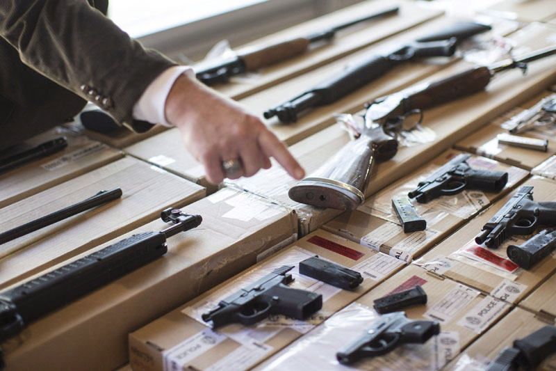 A police officer points out a fire arm as police display guns seized during a series of raids for operation "Project Traveller" at a press conference in Toronto on Friday, June 14, 2013. Police say a violent gang which was terrorizing a northwest Toronto neighbourhood has been dismantled following a series of raids targeting suspected drug and gun traffickers. THE CANADIAN PRESS/Chris Young.