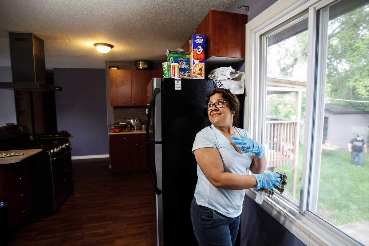 Pilar Ramirez cleans her home after returning as residents re-enter fire-ravaged Fort McMurray, Alta., on Wednesday, June 1, 2016.