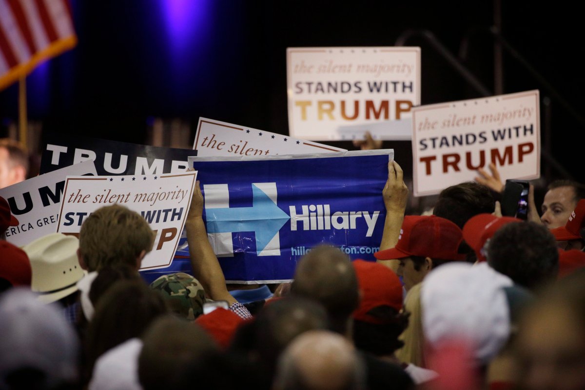 A woman holds up a sign for Democratic presidential candidate Hillary Clinton during a rally for Republican presidential candidate Donald Trump, Thursday, June 2, 2016, in San Jose, Calif. 