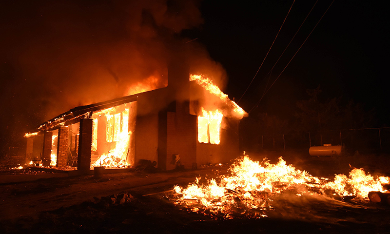 A home is fully engulfed in a fire caused by a fast burning wildfire in the section of South Lake near Lake Isabella, Calif. on Friday, June 24, 2016. 