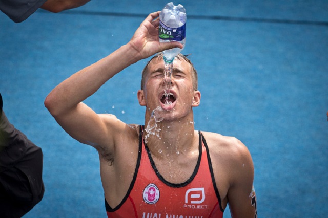 Toronto, On- JULY 12, 2015
Tyler Mislawchuk douses himself with water after kneeling down at the finish line. He finished 10th in the 2015 Pan Am games triathlon on the shore of Lake Ontario in Toronto Sunday morning.        (Lucas Oleniuk/Toronto Star via Getty Images).