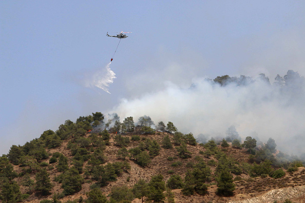 A helicopter drops water on a forest fire in the Cypriot village of Eyrixou in the Troodos mountain area on June 20, 2016.
Aircraft from Britain and Greece have joined Cypriot firefighters in the battle to control some of the worst forest fires to have hit the island in years, officials said. Israel had already sent aircraft to Cyprus when a fire broke out on June 18 at Argaka in the northwestern tourist region of Paphos, fanned by strong winds and scorchingly high temperatures.