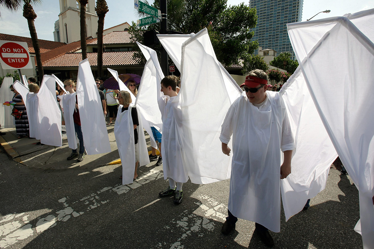 Counter demonstrators dressed as angels to show support and solidarity block the view of protesters near the funeral service for Christopher Andrew Leinonen, one of the victims of the Pulse nightclub mass shooting, outside the Cathedral Church of St. Luke, Saturday, June 18, 2016, in Orlando, Fla. 
