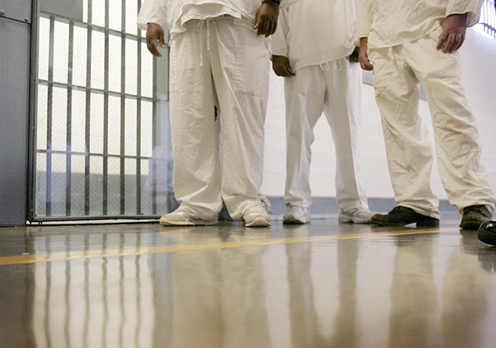 In this Aug. 10, 2009 file photo, inmates at Cummins Unit of the Arkansas Department of Correction wait to be admitted through a gate in the prison near Varner, Ark. 