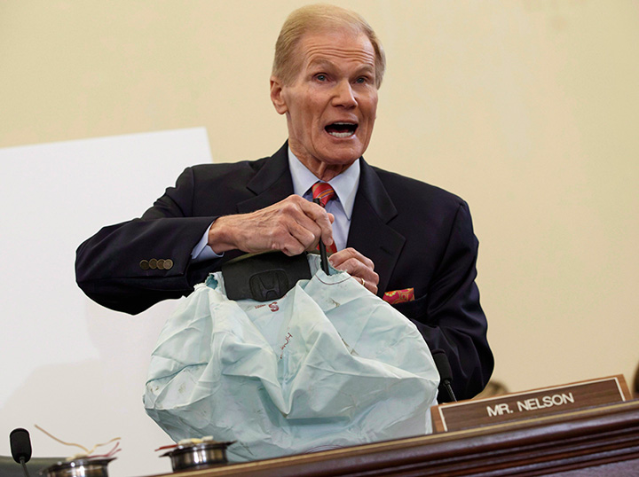 Senate Commerce Committee member Sen. Bill Nelson displays the parts and function of a defective airbag made by Takata during the committee's hearing on Capitol Hill in Washington, Nov. 20, 2014. 