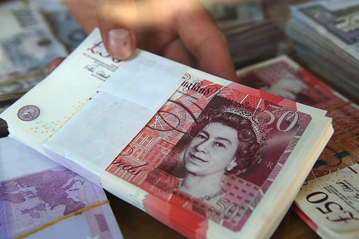 A vendor holds British pound banknotes at a money exchange shop on June 25, 2016.