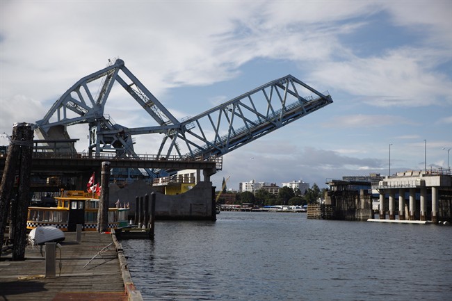 The old Blue Bridge rises for large ships passing through The Johnson Street Bridge Replacement Project, in Victoria, B.C., Friday, June 10, 2016. Known locally as the Blue Bridge for its light blue paint job, the new bridge was originally scheduled to open to traffic last September. 
