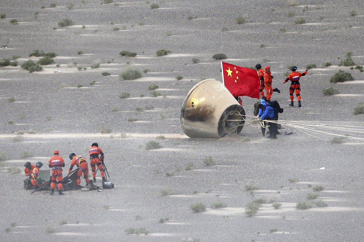 People retrieve a reentry module that was aboard the carrier rocket Long March-7 after it touches down successfully in Badain Jaran Desert in northern China's Inner Mongolia Autonomous Region, June 26, 2016.