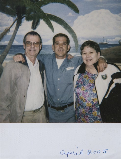 William (Russ) Davies, centre, poses for with his parents, Richard Davies, right, and Carol Davies as they visit their son in a Florida prison in this April 2005 handout photo.