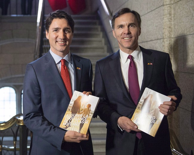 Prime Minister Justin Trudeau and Finance Minister Bill Morneau pose with copies of the 2016 federal budget.