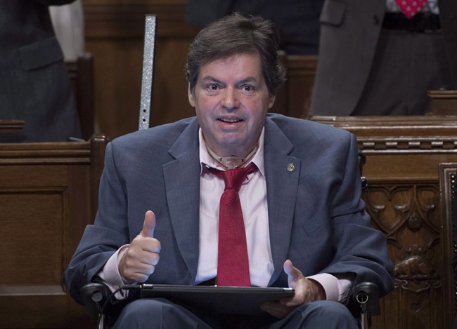 Ottawa-Vanier MP Mauril Belanger gives the thumbs up as he receives applause after using a tablet with text-to-speech program to defend his proposed changes to neutralize gender in the lyrics to "O Canada" in the House of Commons on Parliament Hill in Ottawa on Friday, May 6, 2016. Belanger could see his private member's bill to make the national anthem more gender neutral pass a final hurdle today in the House of Commons.