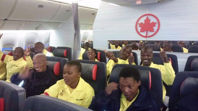 South African firefighters are seen on a an Air Canada plane in Johannesburg, South Africa destined for Edmonton on Sunday, May 29, 2016 in this handout photo. A group that employs 300 South African firefighters on loan to Alberta to battle the Fort McMurray blaze says it is bringing its workers home after they complained about what they are being paid.