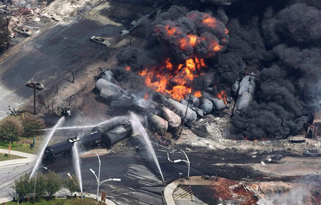 Smoke rises from railway cars that were carrying crude oil after derailing in Lac Megantic, Que., July 6, 2013. The Quebec town that was devastated in 2013 when a runaway train derailed and exploded, killing 47 people, will not pursue legal action against Canadian Pacific Railway.
